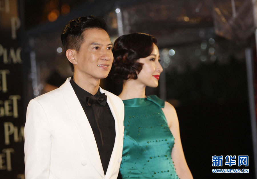 4月17日,艺人张家辉(左)及妻子关咏荷走过红地毯.