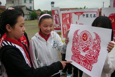 图为嵊州市石璜镇中心小学的学生展示建党90周年的剪纸作品.