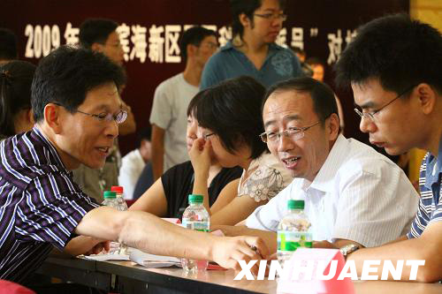 8月27日,在2009年度“滨海新区双百科技特派员计划”对接会上,滨海新区企业代表(右二)与高校教师交流合作意向。当日,天津市举办2009年度“滨海新区双百科技特派员”对接会,滨海新区百余家知名企业与各高校选派的200余名优秀教师和博士生汇聚一堂,交流洽谈,共谋发展。 新华社发(李想 摄)