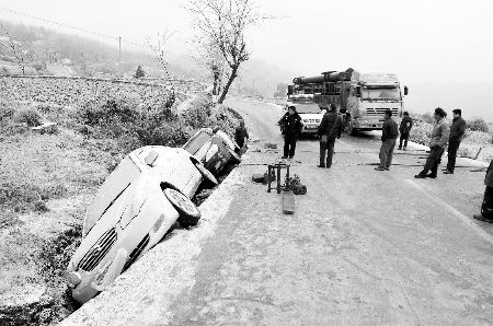 1月2日,在贵州306省道凯里市境内一路段,救援人员准备将两辆滑入路边沟渠的轿车拉回路面新华社/图